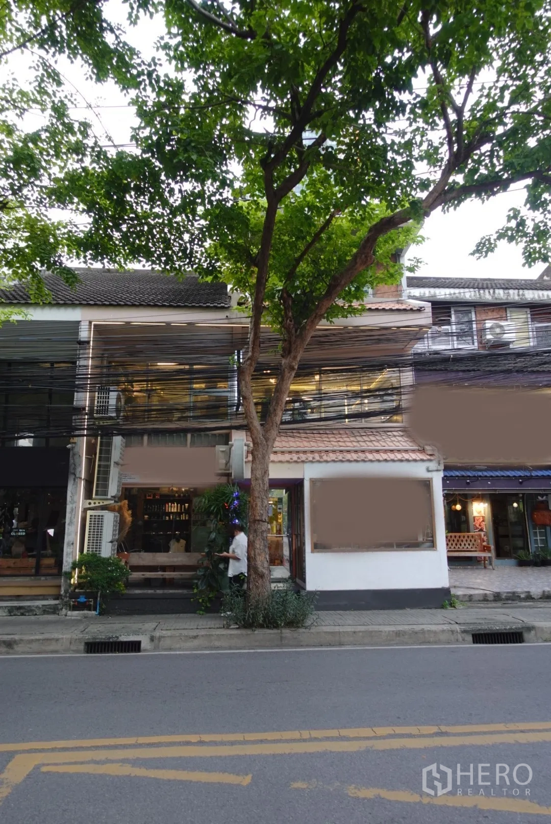 零售空间 出租在Khlong Toei, Bangkok - 临街店面外观，宽大橱窗与行道树，位于คลองเตย的绿荫街道