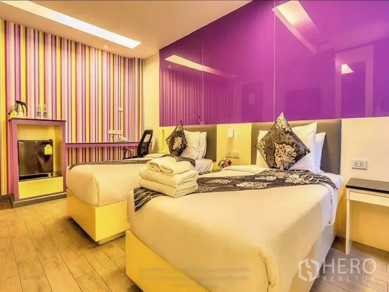 อาคารพาณิชย์ ให้เช่าหรือขายในKhlong Toei, Bangkok - ห้องนอนเตียงคู่ผนังไฮไลต์สีม่วง ลายทาง และโต๊ะทำงาน