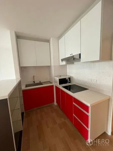 คอนโด ให้เช่าในWatthana, Bangkok - ครัวขนาดกะทัดรัด ตู้ล่างสีแดง เตา เครื่องดูดควัน และไมโครเวฟ