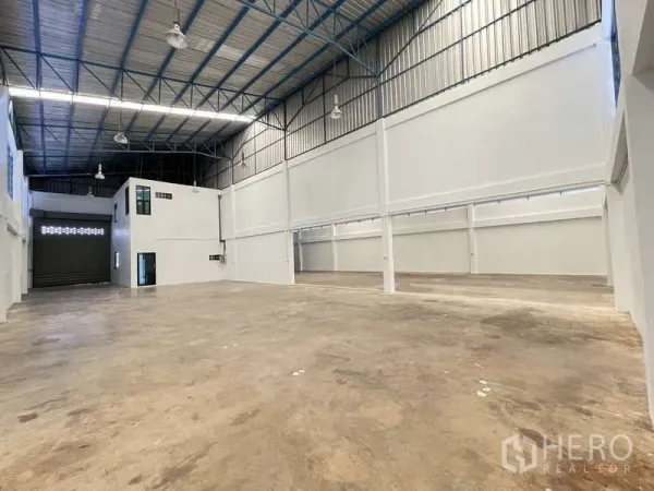 Factory for rent in Ban Phaeo, Samut Sakhon - Spacious high-ceiling warehouse interior with steel truss roof and office block.