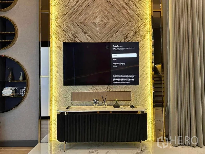 Detached House for sale in Suan Luang, Bangkok - TV feature wall with backlit stone cladding and sleek media console.