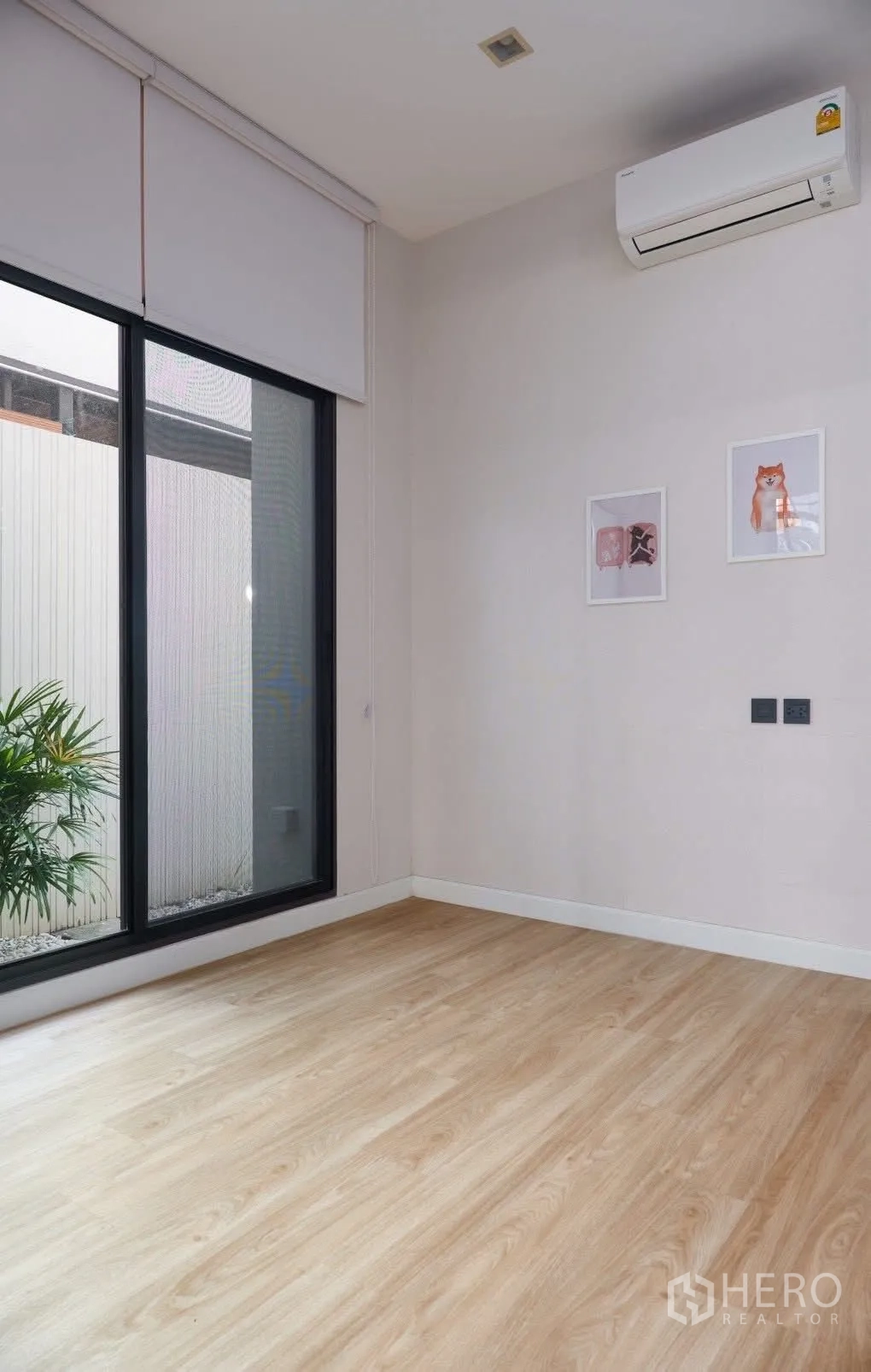 独栋房屋 for rent in Phra Khanong, Bangkok - 一层房间，推拉落地门通向小花园，壁挂空调。