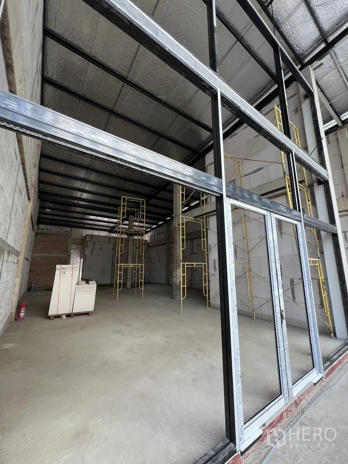 พื้นที่ขายปลีก ให้เช่าในKhlong Toei, Bangkok - หน้าร้านกระจกบานเลื่อนกำลังก่อสร้าง มีนั่งร้านภายใน