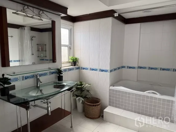 คอนโด ให้เช่าในWatthana, Bangkok - ห้องน้ำสว่าง อ่างล้างหน้าแบบท็อปกระจก กระเบื้องสีขาว และอ่างอาบน้ำยกระดับมีขั้นขึ้น.