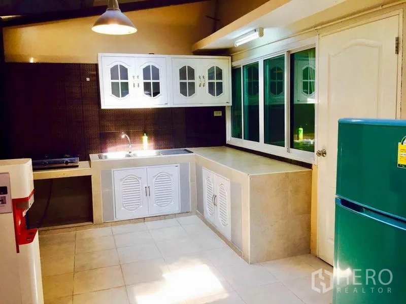 ทาวน์เฮาส์ ให้เช่าหรือขายในPrawet, Bangkok - ห้องครัวรูปตัวแอล ตู้บิวท์อินสีขาว อ่างล้างจาน เตา และหน้าต่างบานใหญ่