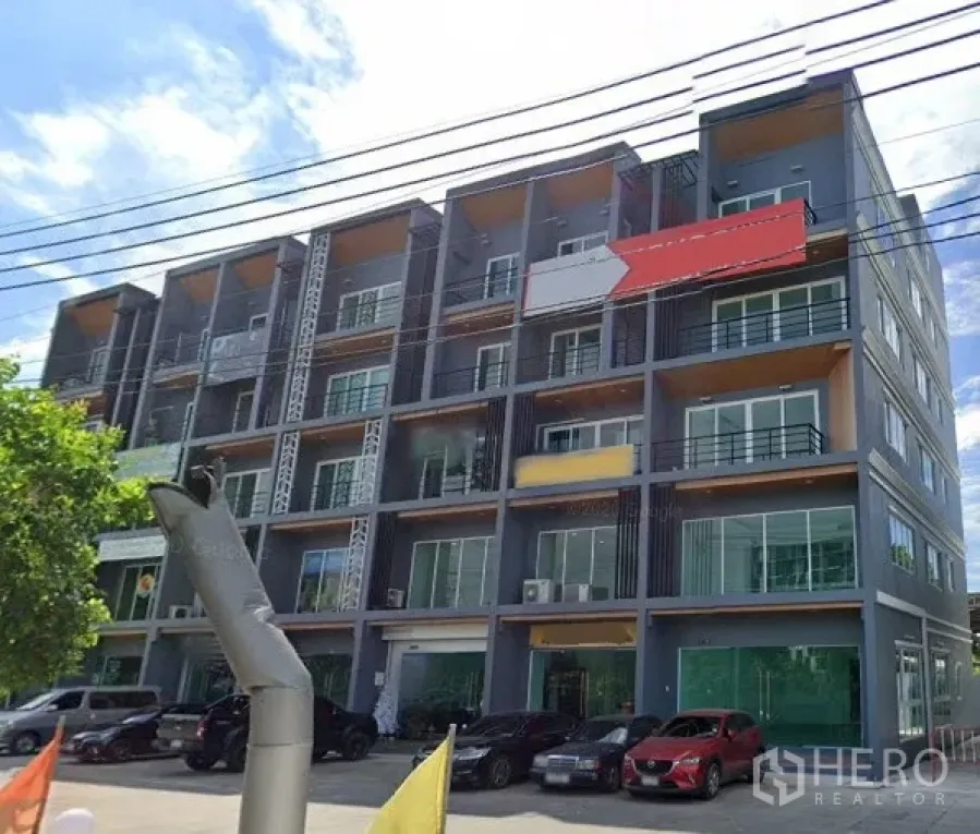 Home Office for rent in Bueng Kum, Bangkok - Modern multi-storey home office building with glass frontage and ground parking in Bueng Kum, Bangkok on a sunny day.