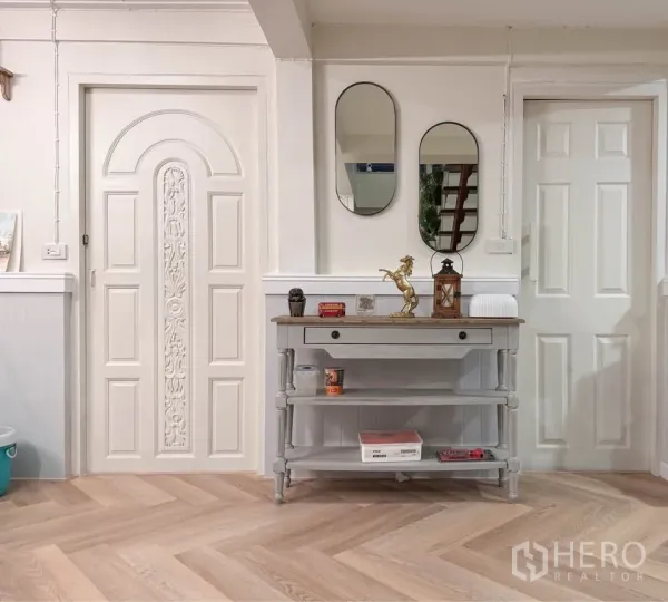 บ้าน ให้เช่าในHuai Khwang, Bangkok - โถงทางเข้าพร้อมประตูบัวลาย กระจกเงา และโต๊ะคอนโซลบนพื้นไม้.