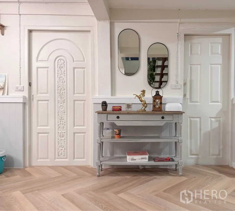 บ้าน ให้เช่าในHuai Khwang, Bangkok - โถงทางเข้าพร้อมประตูบัวลาย กระจกเงา และโต๊ะคอนโซลบนพื้นไม้.