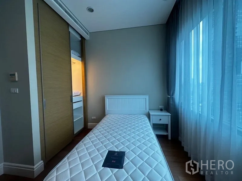 คอนโด ให้เช่าในKhlong Toei, Bangkok - ห้องนอนเดี่ยวมีตู้เสื้อผ้าบานเลื่อน โต๊ะข้าง และหน้าต่างกว้าง