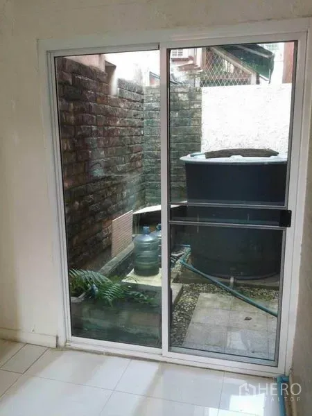 Home Office for rent in Watthana, Bangkok - Sliding glass door opening to a small service yard with a water tank.