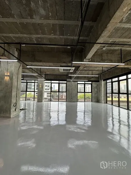 Office Space for rent in Khlong Toei, Bangkok - Open-plan corner office in industrial style with glazing on two sides, reflective flooring and exposed services ready for fit-out overlooking the Sukhumvit skyline.
