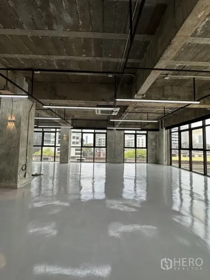Office Space for rent in Khlong Toei, Bangkok - Open-plan corner office in industrial style with glazing on two sides, reflective flooring and exposed services ready for fit-out overlooking the Sukhumvit skyline.