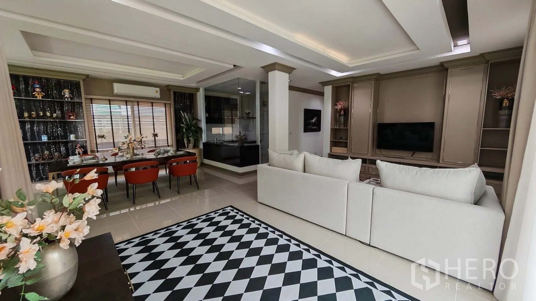 Detached House for rent or sale in Bang Phli, Samut Prakan - Open-plan living with a TV feature wall, dining zone, and a glass-walled kitchen corner.