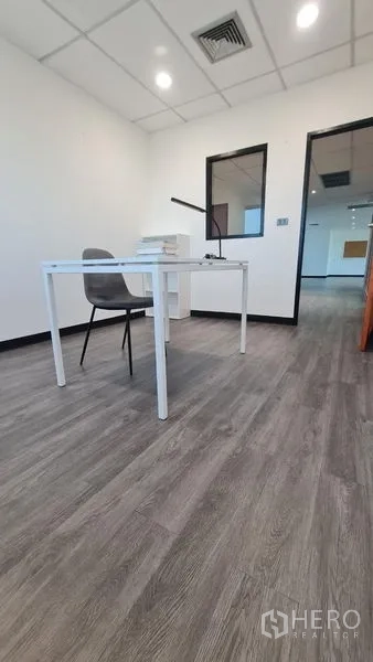 Office Space for rent in Watthana, Bangkok - Small office with a simple desk, chair and wood-look flooring.