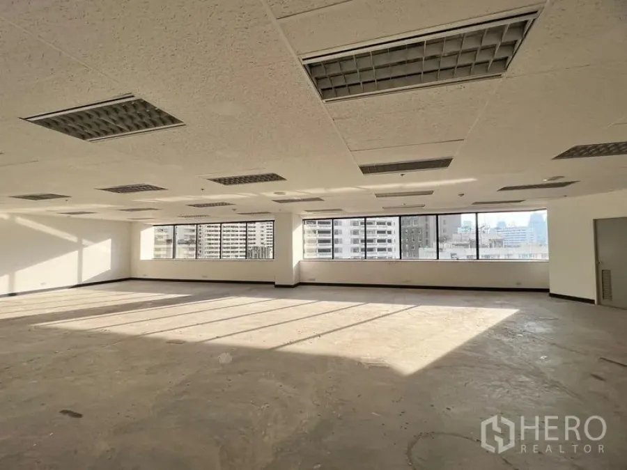 Office Space for rent in Khlong Toei, Bangkok - Spacious 204 sqm office interior with suspended ceiling, air‑conditioning vents, and skyline outlook.