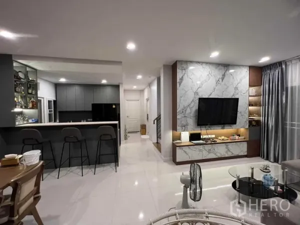 บ้าน ให้เช่าหรือขายในLat Krabang, Bangkok - พื้นที่นั่งเล่นแบบเปิดโล่ง มองไปยังเคาน์เตอร์บาร์และครัวบิวท์อินสีเทา