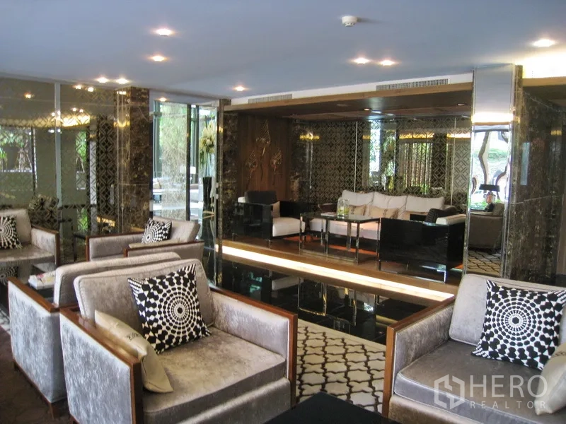 Condominium for rent in Watthana, Bangkok - Residents’ lounge with plush armchairs, sofas, and patterned decor.