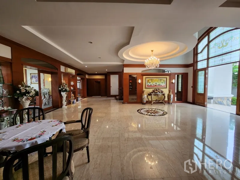 独立式住宅 出租在Prawet, Bangkok - 入口起居区，吊顶灯饰与拱形落地窗引入充足采光。