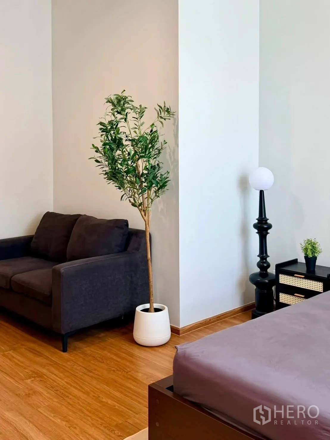 Townhouse for rent in Bang Phli, Samut Prakan - Spacious bedroom with wood floor, sofa, potted plant, and bed.