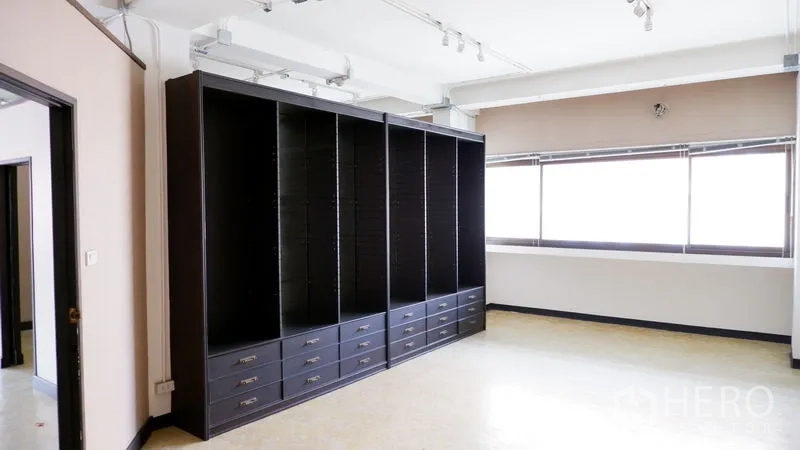 สำนักงาน ให้เช่าในWatthana, Bangkok - มุมทำงานสว่าง พร้อมตู้บิวท์อินสีเข้มแบบเต็มผนังและลิ้นชัก ข้างหน้าต่างบานกว้าง