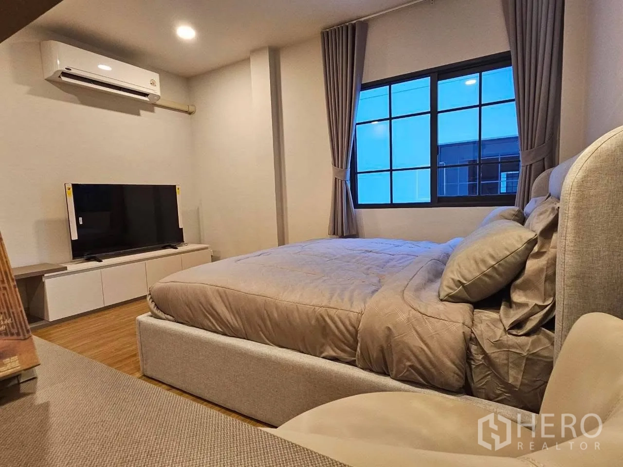 独栋房屋 for rent or sale in Bang Phli, Samut Prakan - 温馨卧室，软包大床、电视柜、空调与带窗帘的窗户。