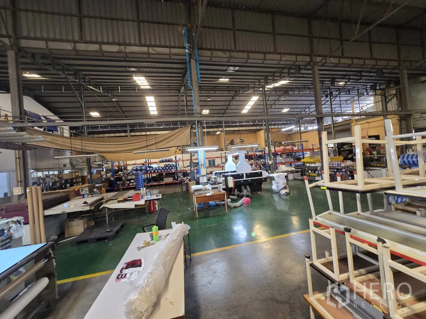 Factory for rent in Sam Phran, Nakhon Pathom - Manufacturing area with worktables, shelving, and green epoxy flooring.