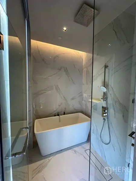 Condominium for rent - Modern bathroom with freestanding bathtub, rain shower and marble walls.