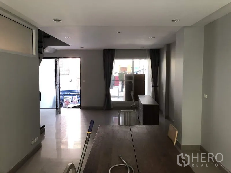 ทาวน์เฮาส์ ให้เช่าในYan Nawa, Bangkok - มุมกลับของห้องนั่งเล่น-ทานอาหาร มีระเบียงหน้า-หลังและผ้าม่านสูงจรดเพดาน