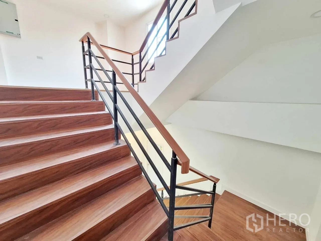 Home Office for sale in Bueng Kum, Bangkok - Close view of wooden steps and black metal railings on the stairwell.