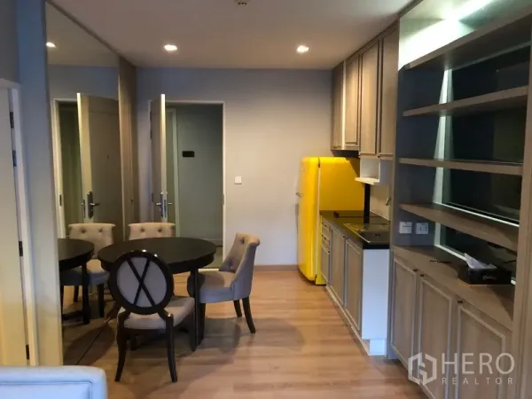 คอนโด ให้เช่าในPathum Wan, Bangkok - ครัวเปิดและโต๊ะทานอาหารพร้อมตู้เย็นสีเหลืองและชั้นเก็บของบิลท์อิน