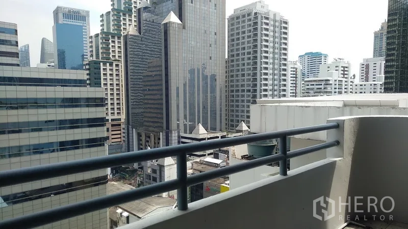Condominium for sale in Watthana, Bangkok - Private balcony with railings facing the Bangkok Sukhumvit skyline of high-rise offices.