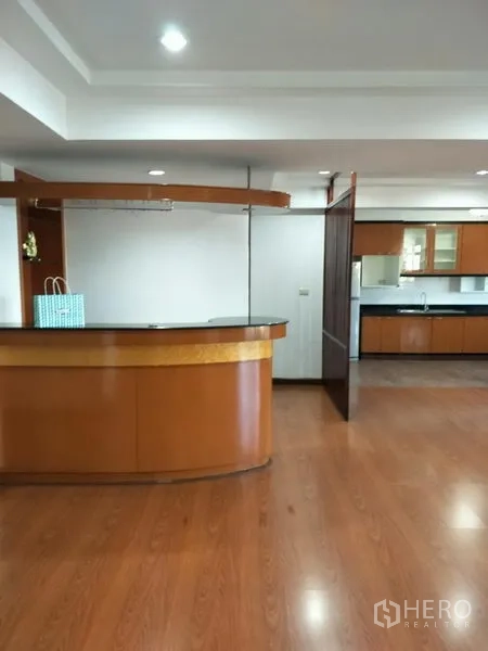 Condominium for rent in Watthana, Bangkok - Open-plan living area with wooden floors and a built-in bar counter at Royal Castle condo in Phrom Phong, Watthana, Bangkok.