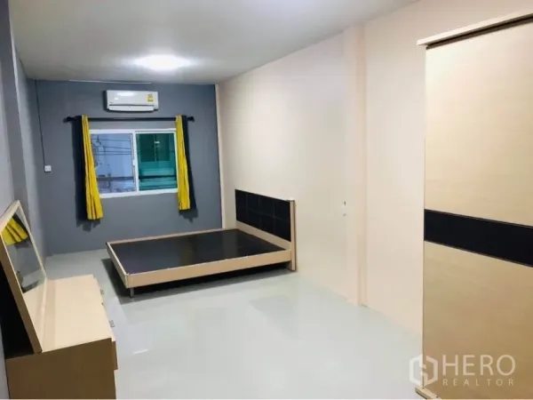 联排别墅 出租或出售在Huai Khwang, Bangkok - 带空调的卧室，床架、衣柜与带窗帘的窗户。