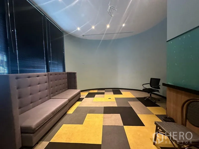 สำนักงาน ให้เช่า - เลานจ์ประชุมผนังโค้ง โซฟายาว พื้นพรมลายเหลือง‑เทา และมู่ลี่ทึบแสง