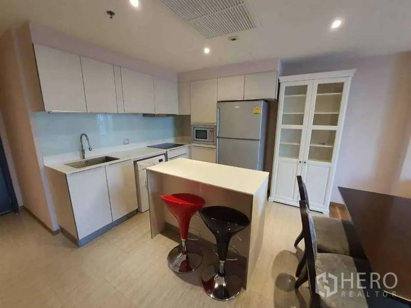 公寓 出售在Watthana, Bangkok - 现代白色厨房，带中岛吧台与全尺寸家电。