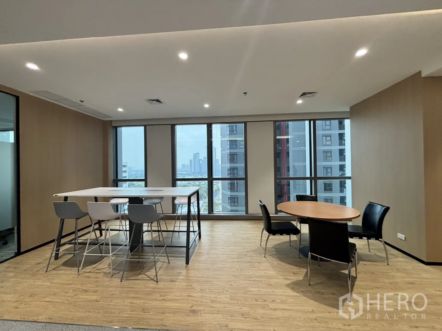 Office Space for rent in Huai Khwang, Bangkok - Collaborative lounge with high table and stools overlooking the city skyline.