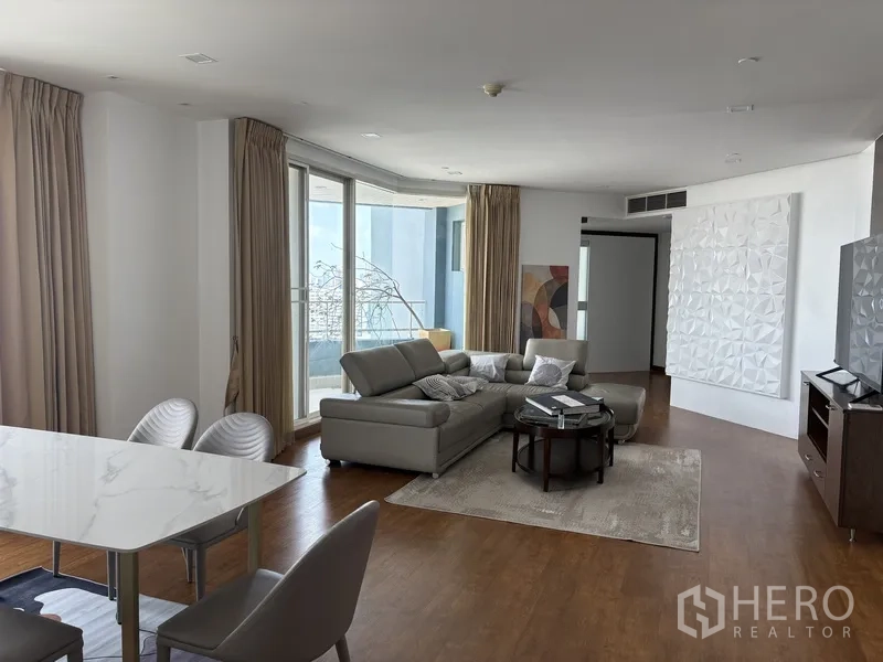 คอนโด for rent in Khlong San, Bangkok - ห้องนั่งเล่นสว่าง โซฟาหนังทรงตัวแอล พรม และประตูกระจกบานใหญ่