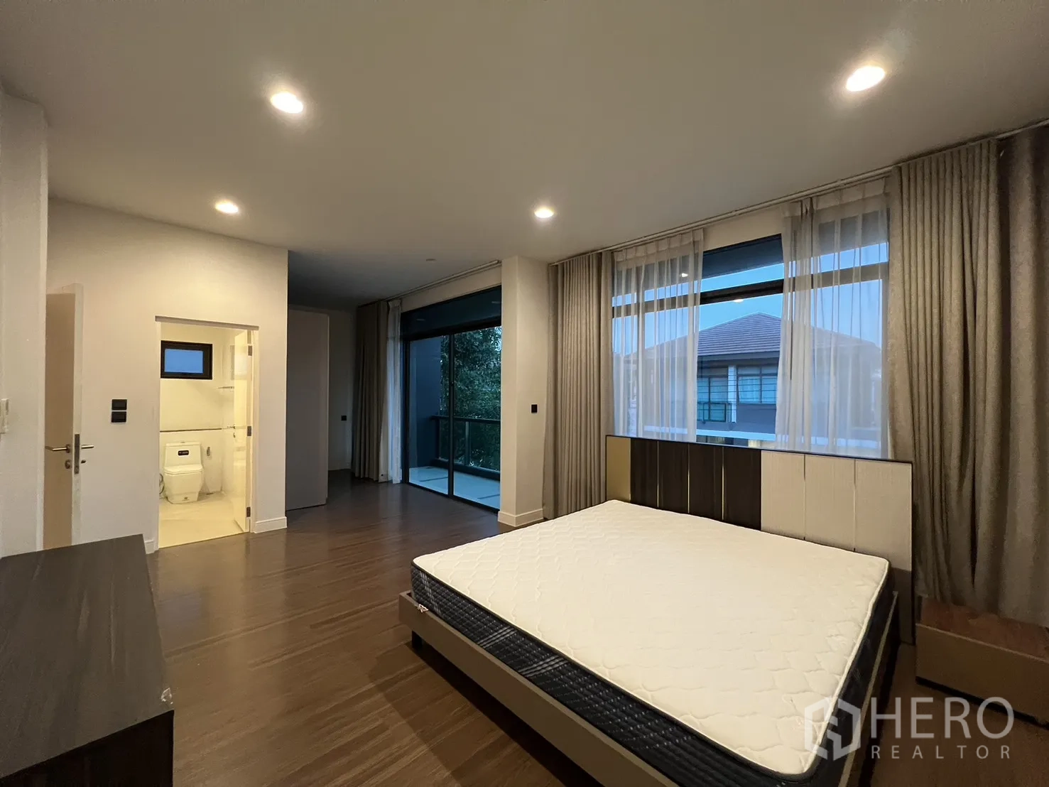 บ้าน ให้เช่าหรือขายในBang Kapi, Bangkok - ห้องนอนใหญ่มีผ้าม่าน ตู้วางทีวี และพื้นไม้