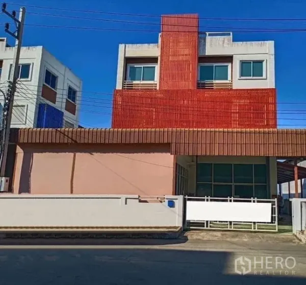 工厂 出售在Pathum Thani - 现代工厂外立面，红色格栅幕墙，大门与前方空地。