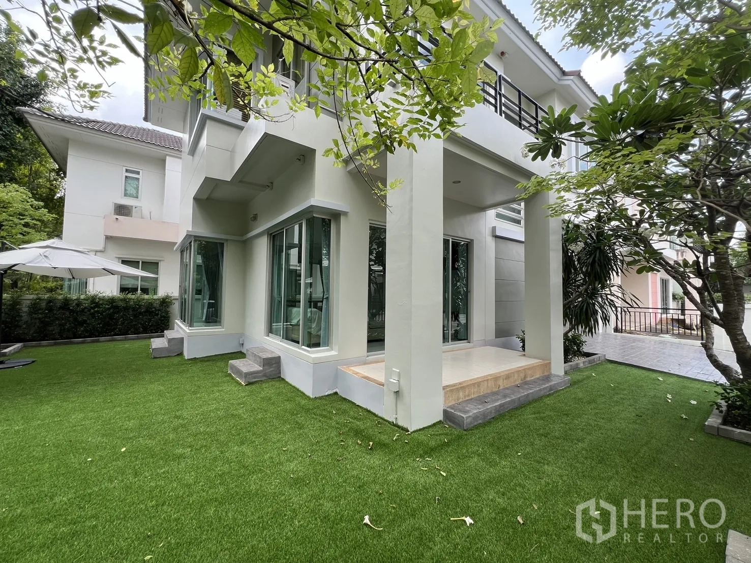 独立式住宅 出租在Saphan Sung, Bangkok - 房屋后侧带有小台阶的有顶露台与环绕草地