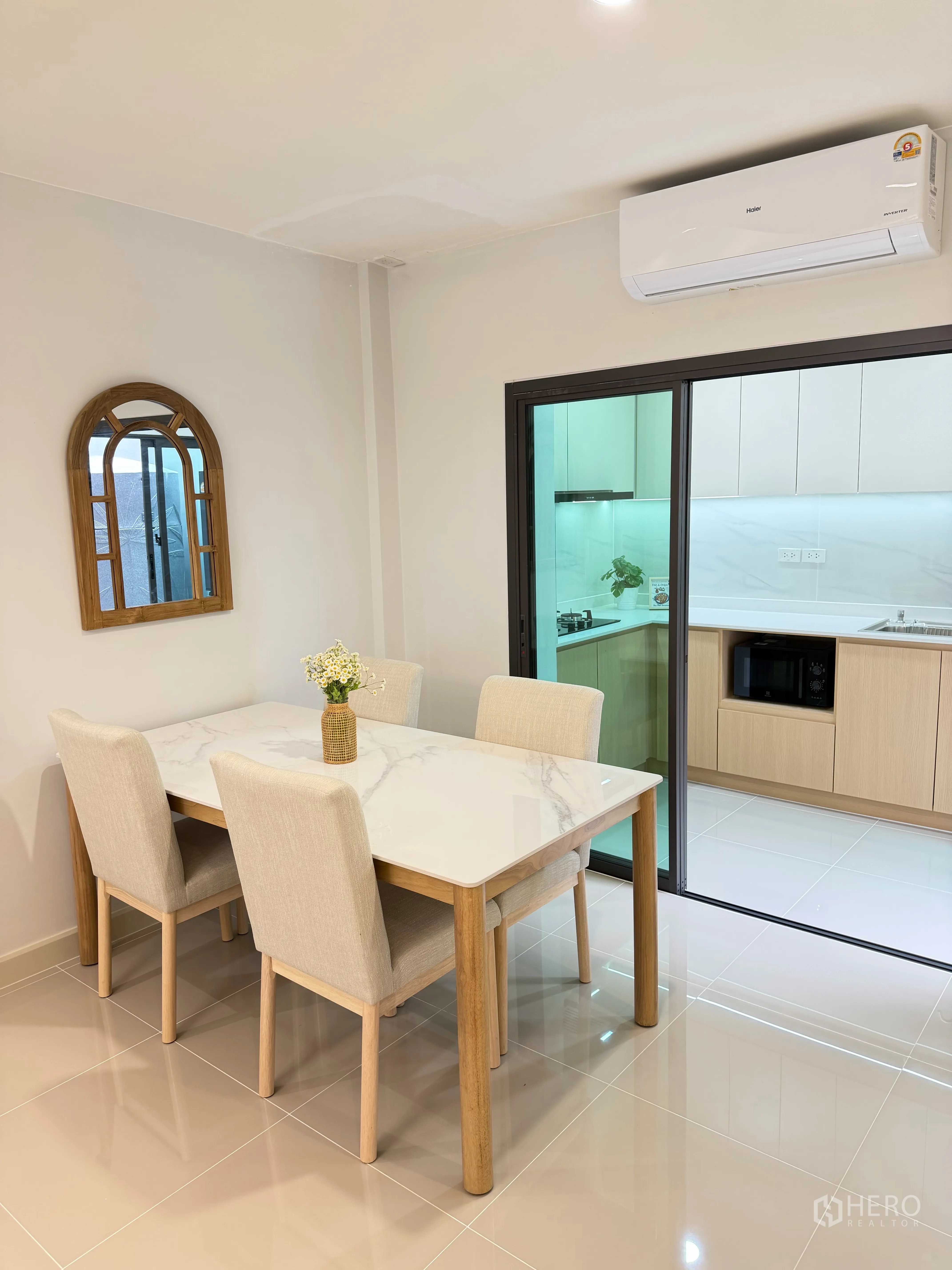 Townhouse for rent in Bang Phli, Samut Prakan - Dining area with marble-top table for four beside a sliding glass kitchen door.