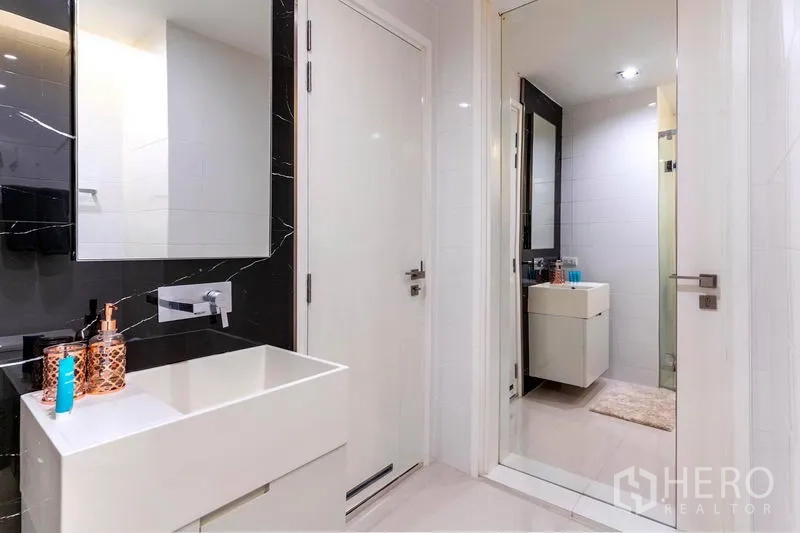 คอนโด ให้เช่าในWatthana, Bangkok - ห้องน้ำโทนขาว อ่างล้างหน้าทรงสี่เหลี่ยม ตู้กระจก และทางเข้าห้องอาบน้ำกระจก