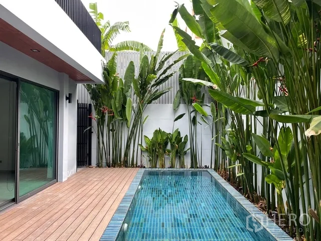 Detached House for rent in Watthana, Bangkok - Pool and wooden deck beside the house with lush plants.