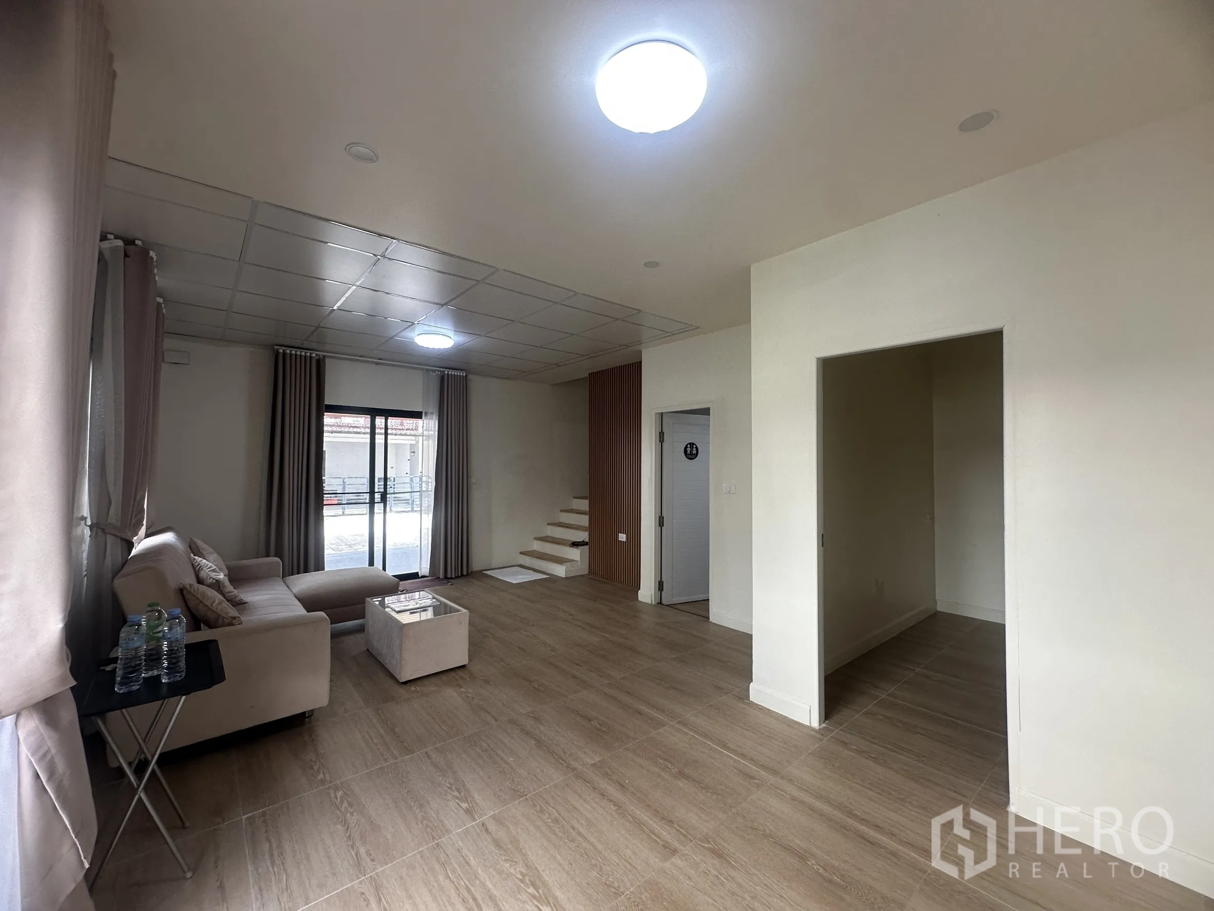 联排别墅 for sale in Lam Luk Ka, Pathum Thani - 客厅装有筒灯并设有楼梯下储物空间。