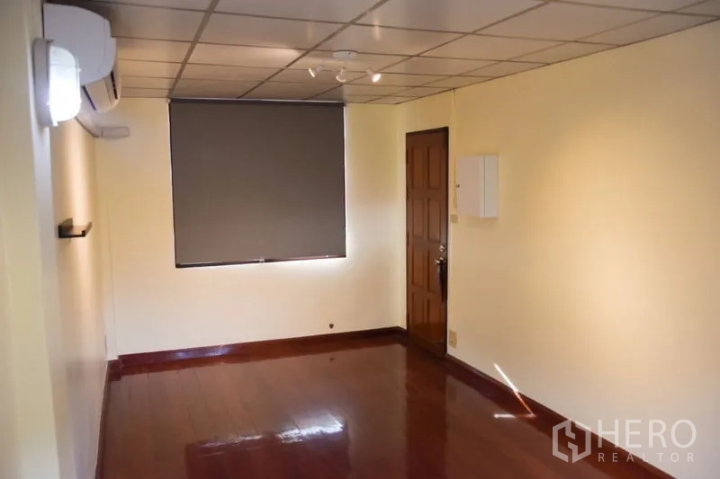 联排别墅 出租在Watthana, Bangkok - 楼上房间，木地板、卷帘与空调机。