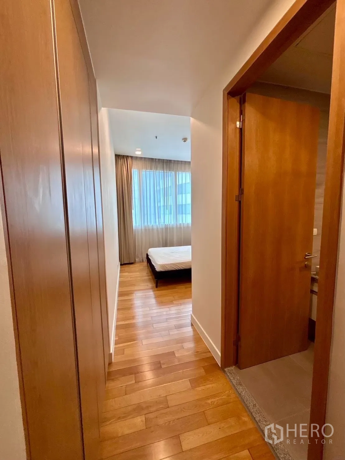 Condominium for rent in Khlong Toei, Bangkok - Corridor with built-in closets and doorway to bathroom