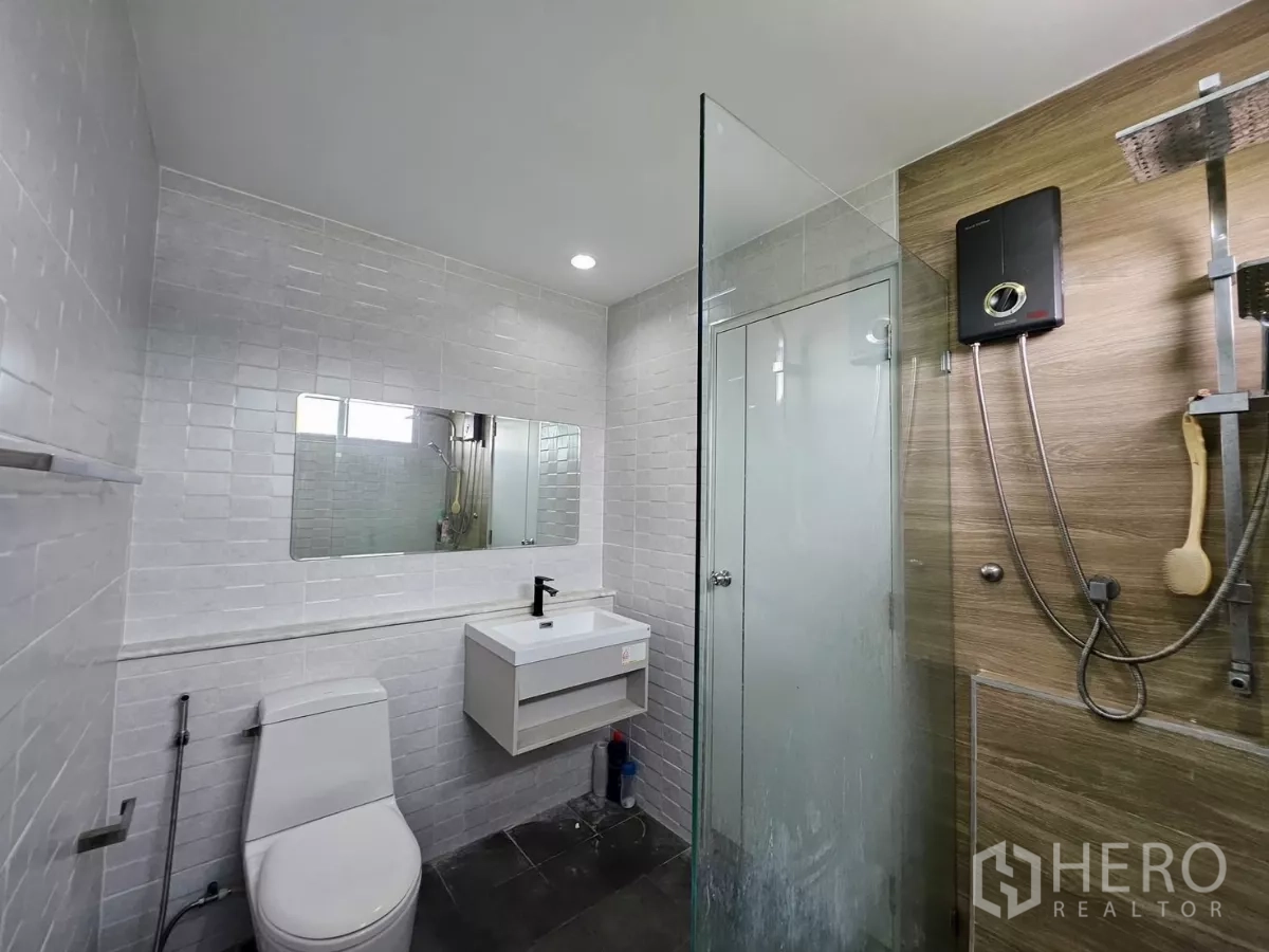 独立式住宅 出租在Khlong Toei, Bangkok - 翻新卫生间，玻璃淋浴房、顶喷花洒、白色地铁砖与台盆柜。