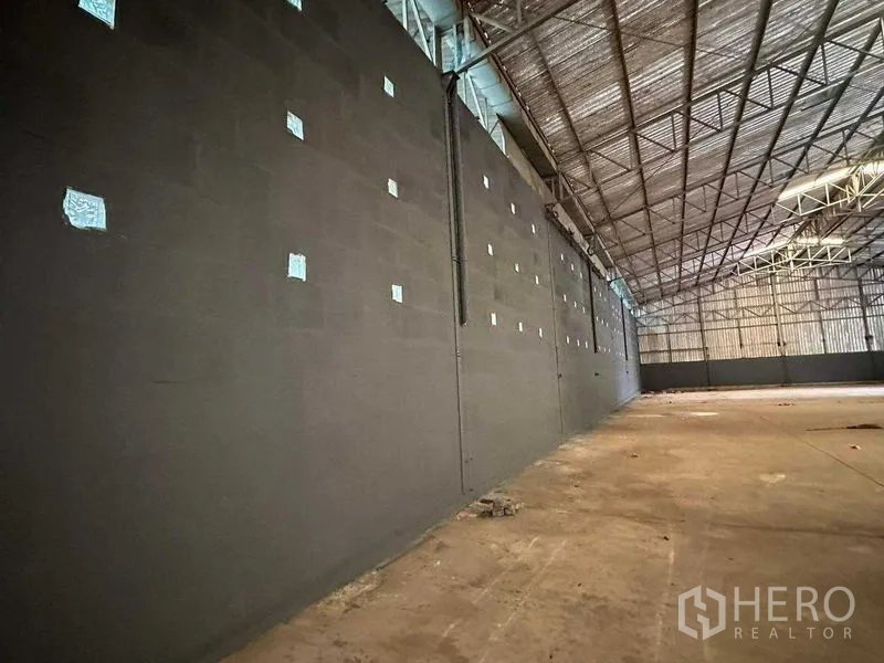 Warehouse for rent in Phra Nakhon Si Ayutthaya - Interior wall with ventilation blocks beneath the truss roof structure.