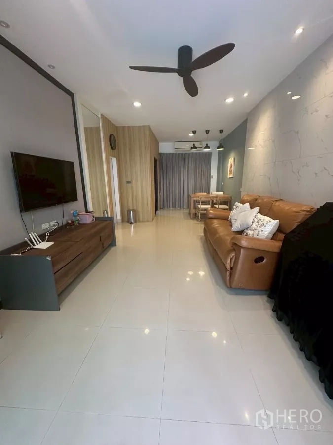 Townhouse for rent in Chom Thong, Bangkok - Open-plan living area with leather sofa, ceiling fan and recessed lights.