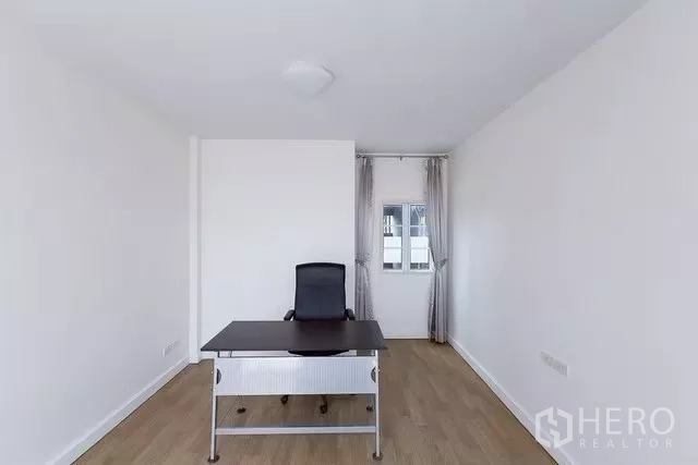 Townhouse for rent in Watthana, Bangkok - Home office or bedroom with desk, chair and a door to a small balcony.